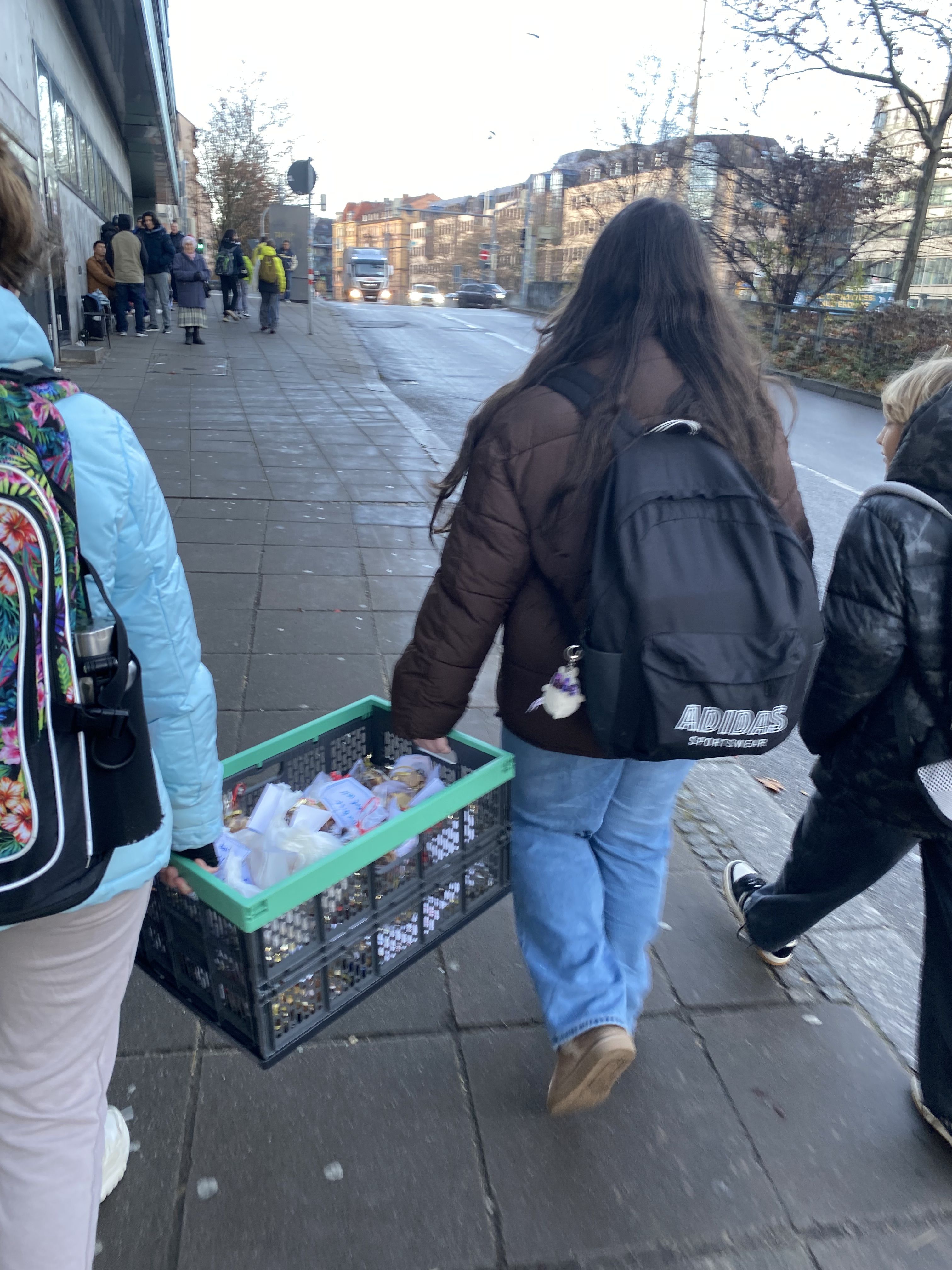 Die Schülerinnen und Schüler mit einer vollen Klappbox mit Plätzchen auf dem Weg zu einer sozialen Einrichtung.