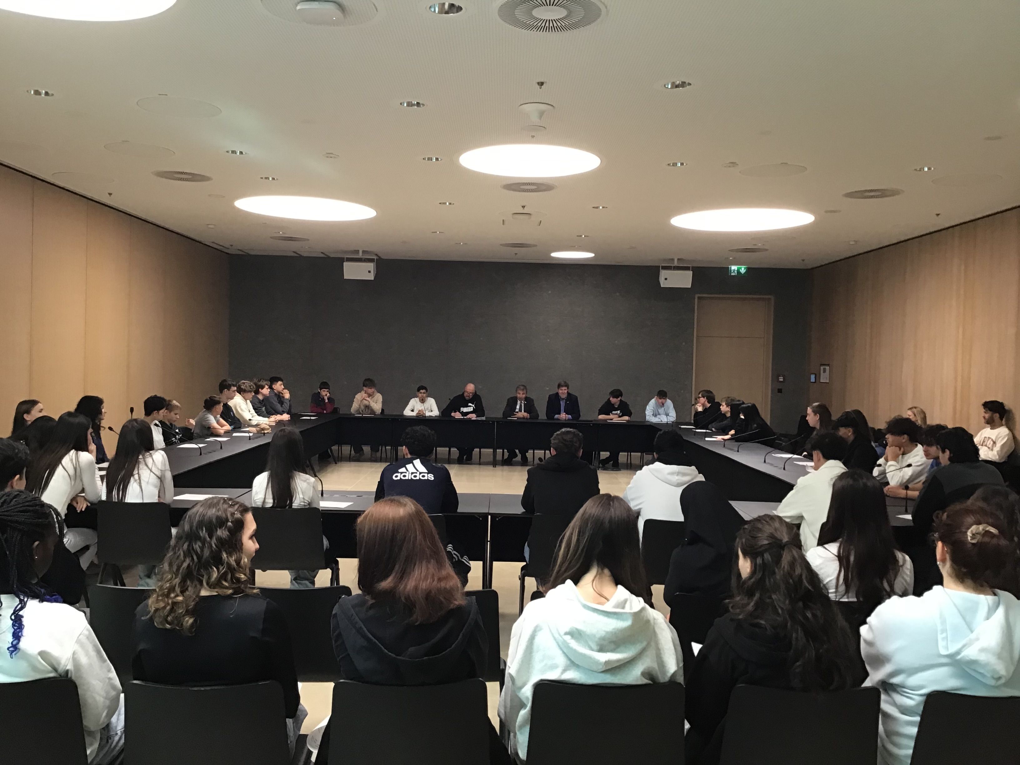 Schülerinnen und Schüler in einem Konferenzsaal im Gespräch mit Landtagsabgeordneten
